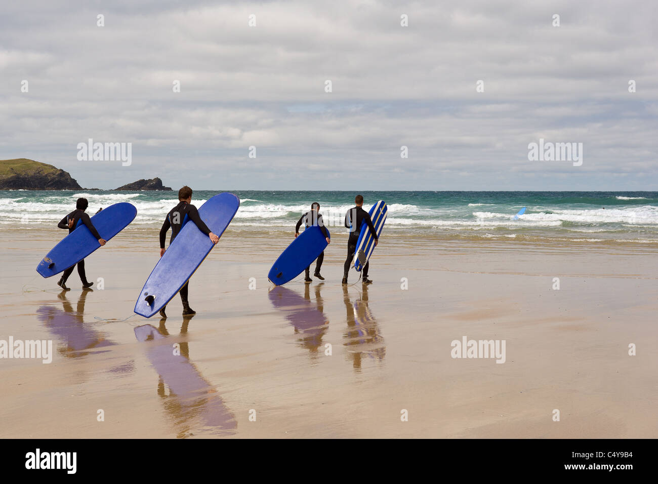 Un groupe de surfers à pied de la mer sur la plage de Fistral à Newquay. Cornwall. UK. Banque D'Images