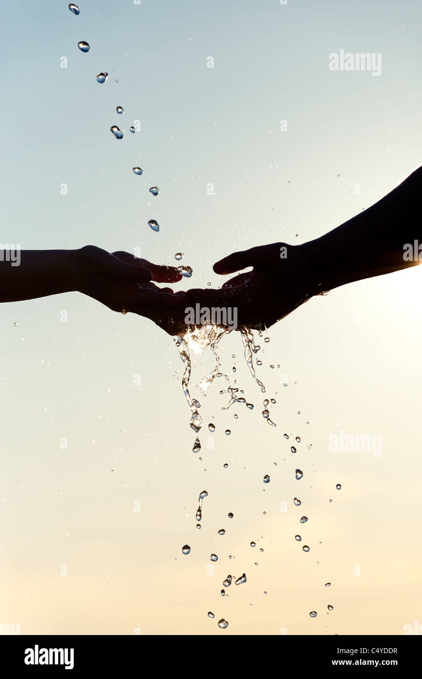 Les mains de childrens éclaboussé avec de l'eau. Silhouette Banque D'Images