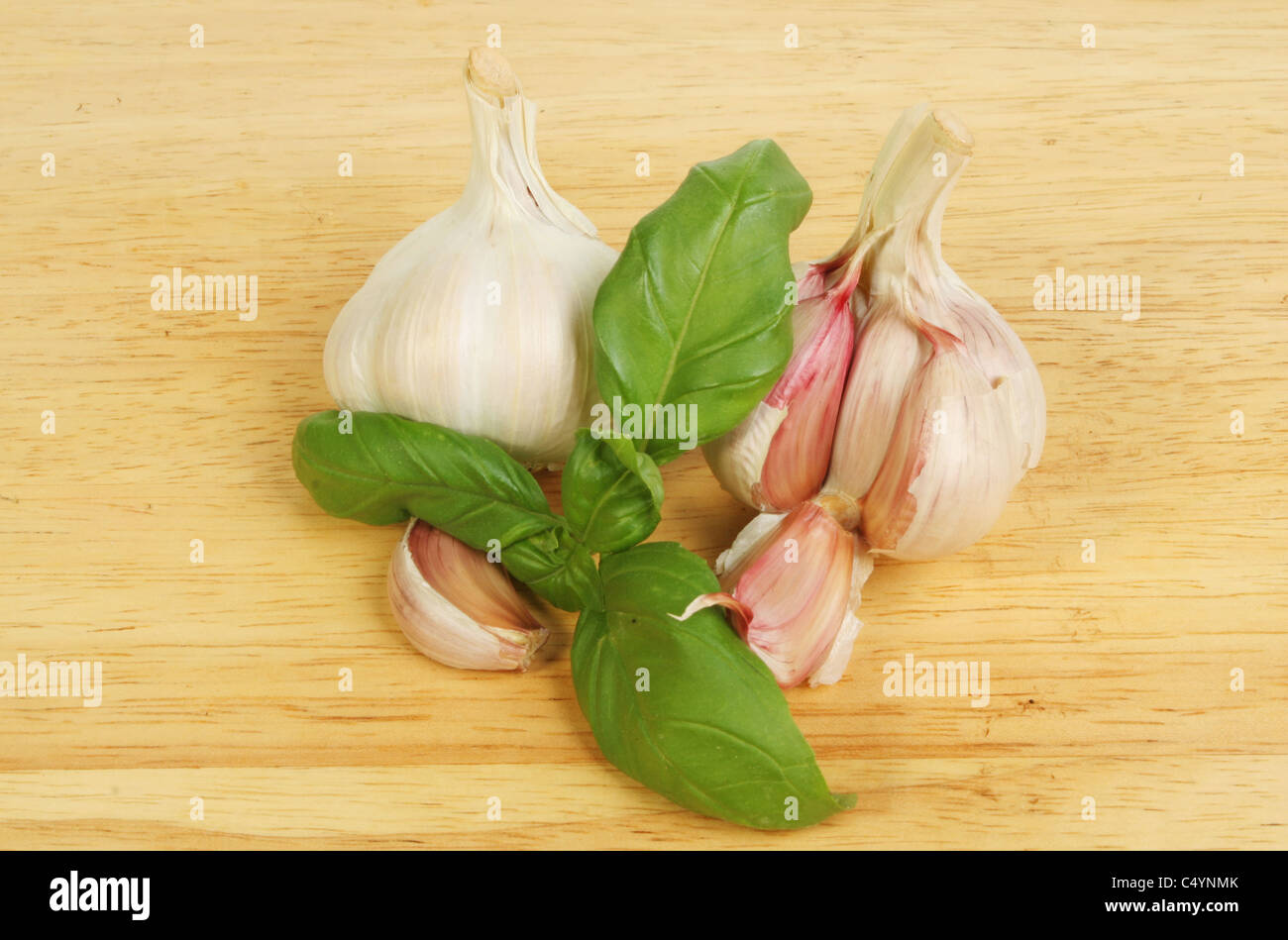 Bouquet de basilic avec l'ail l'ail et de girofle sur une planche en bois Banque D'Images