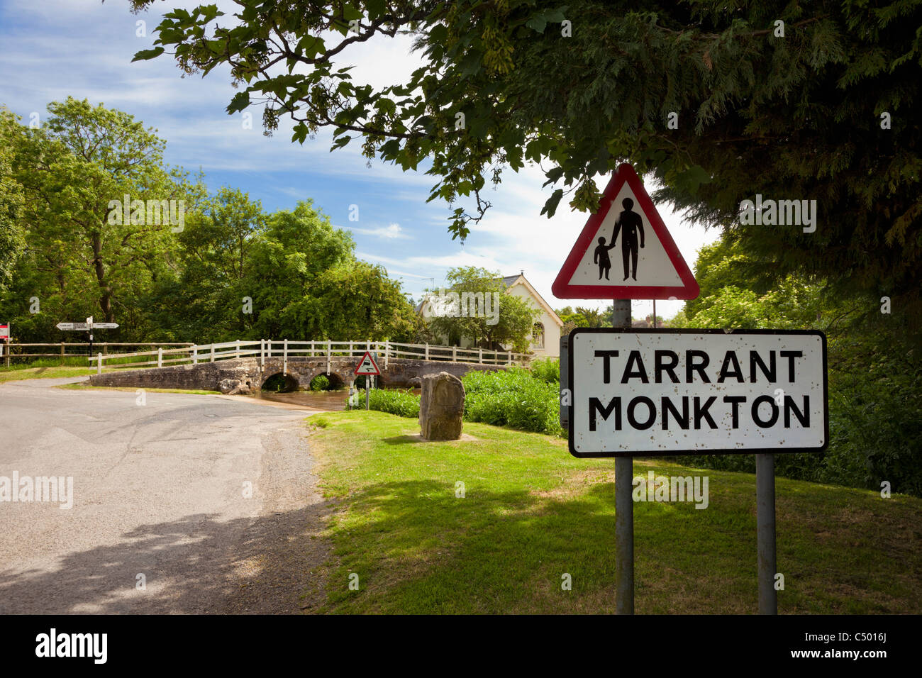 Tarrant Monkton village signe et ford, Dorset, Angleterre, Royaume-Uni avec piétons traversant marchant dans le panneau d'avertissement de la route. Banque D'Images