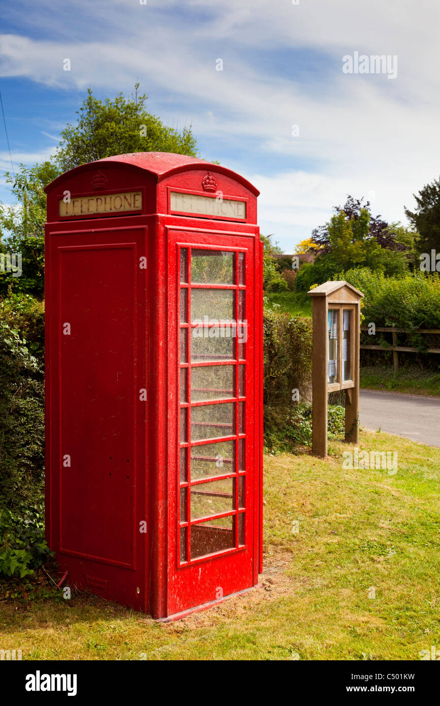La traditionnelle boîte de téléphone rouge et village noticeboard, England, UK Banque D'Images