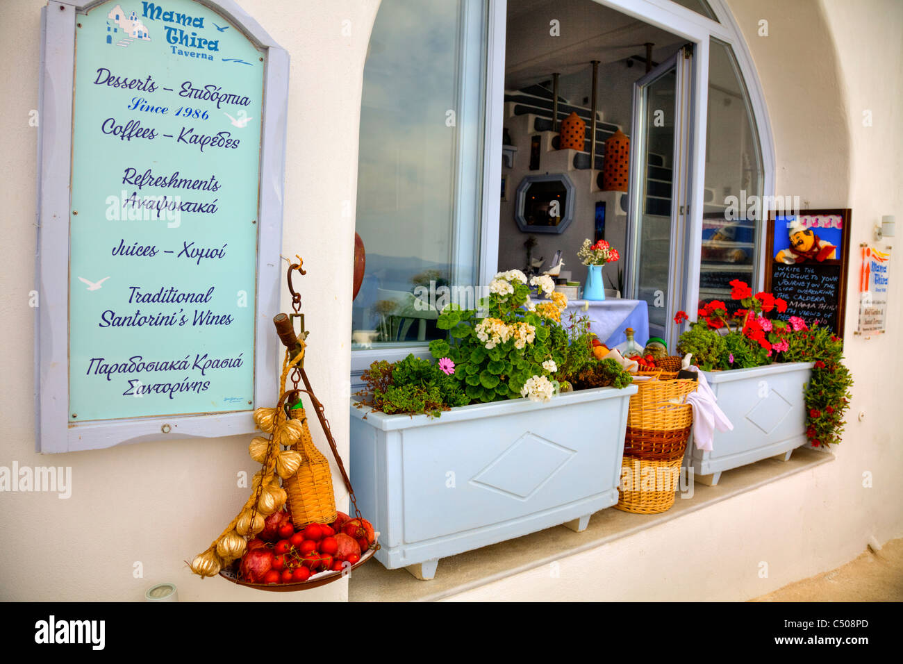 Typique de Santorin île grecque restaurant emblématique à Thira boîte à fleurs et des aliments à l'extérieur du menu Banque D'Images
