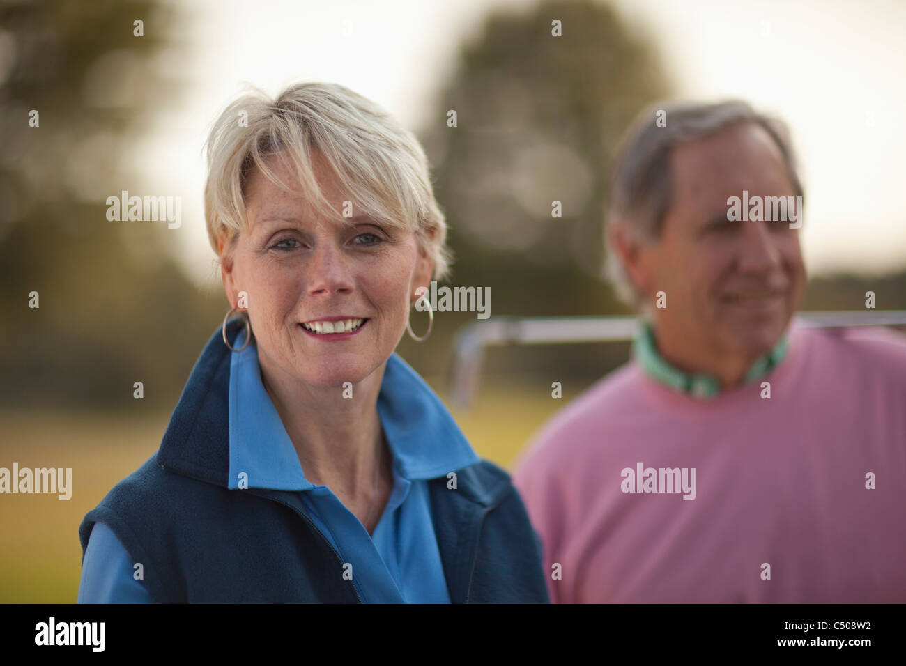 Caucasian couple standing on golf course Banque D'Images