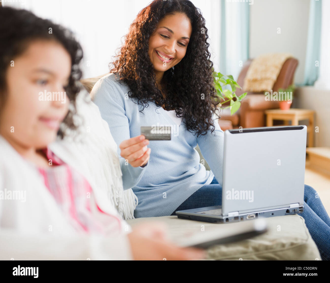 Mixed Race woman shopping online with credit card Banque D'Images