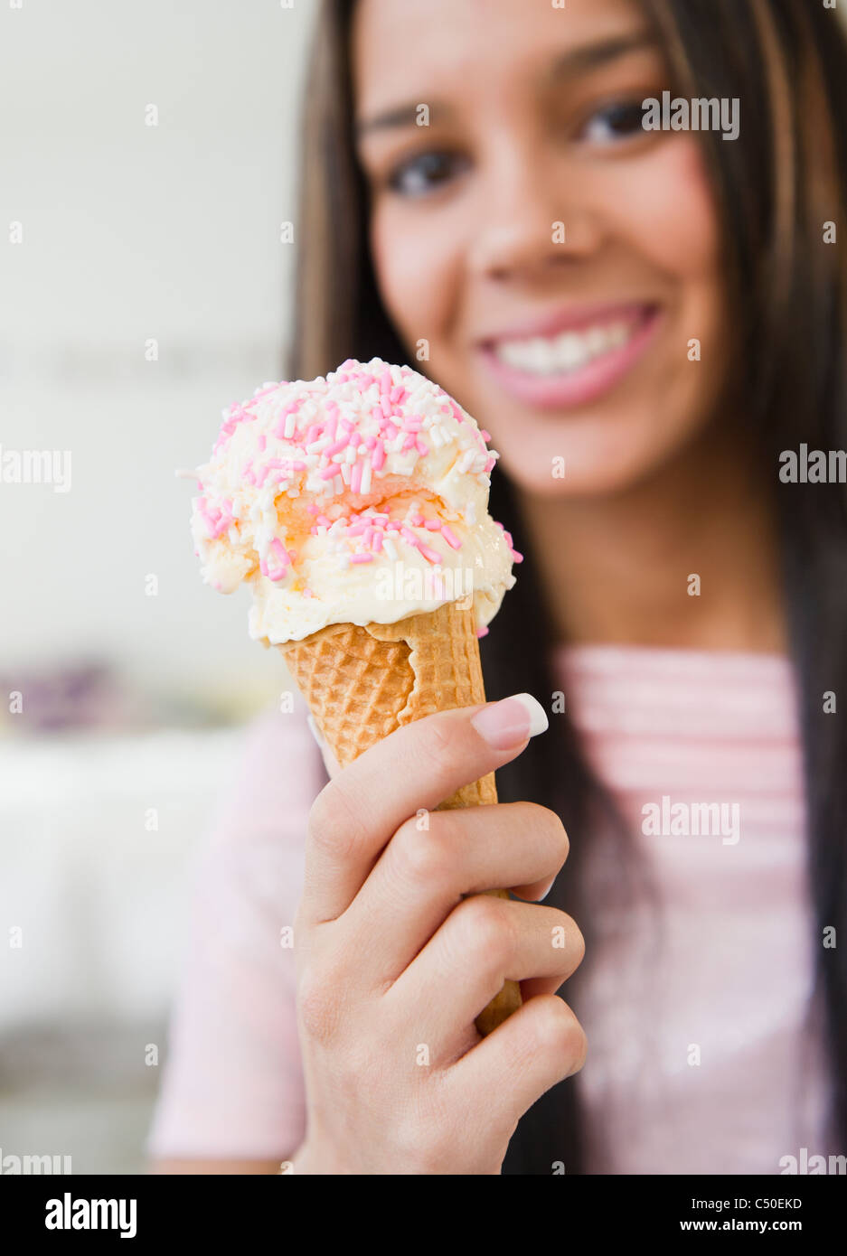 Hispanic teenager eating ice cream cone Banque D'Images