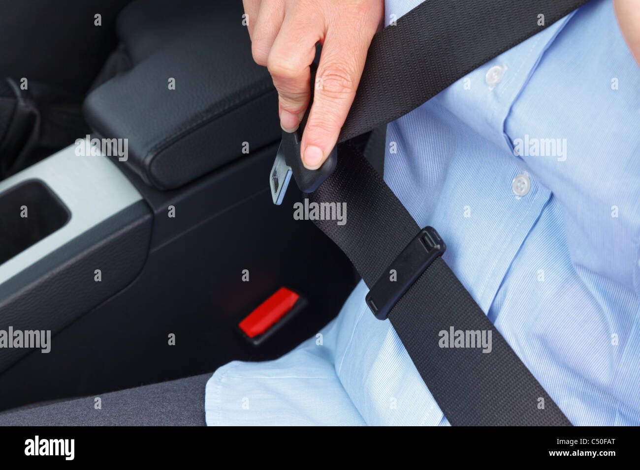 Photo d'une business woman sitting in a car mettre sur sa ceinture de siège Banque D'Images