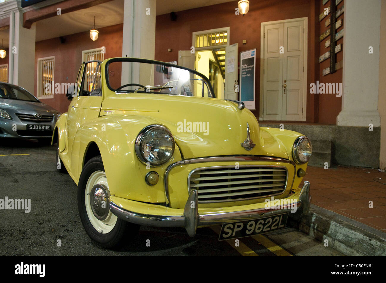 Voiture classique jaune en face d'un bar de nuit, vintage car, à Singapour, en Asie du Sud-Est, l'Asie Banque D'Images