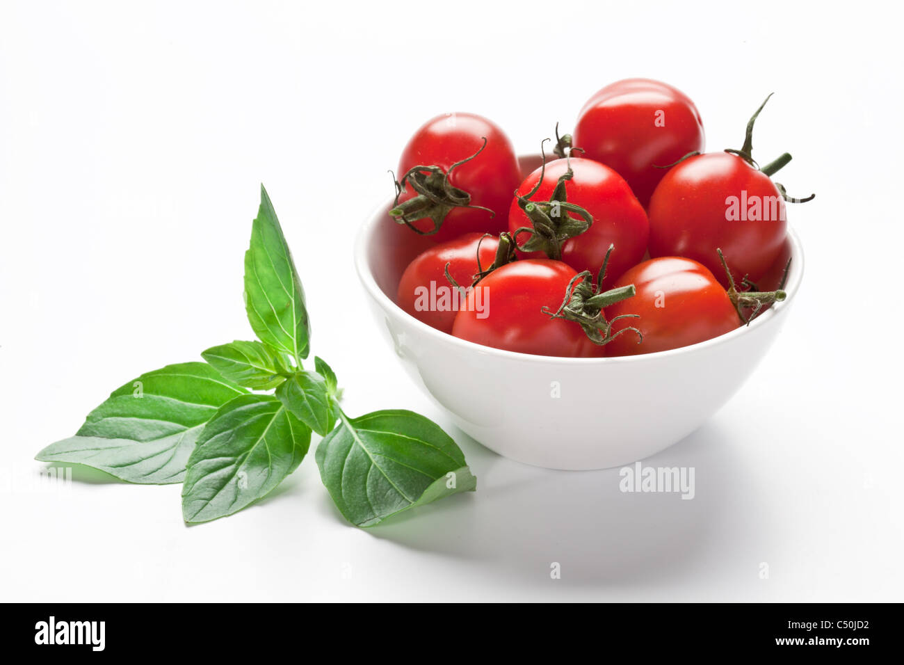 Bol avec tomates fraîches isolées sur fond blanc. Banque D'Images