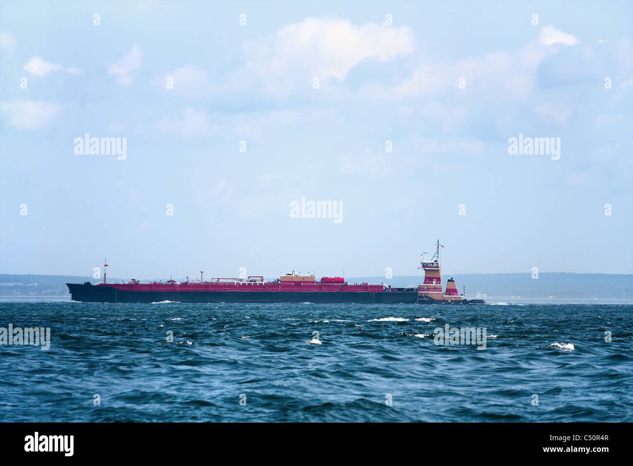 Une longue péniche un navire ou un bateau au loin sur la mer bleue. Banque D'Images