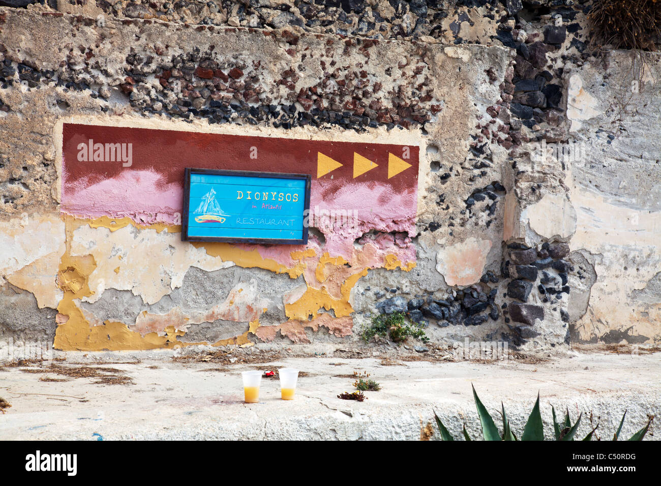 Typique de Santorin île grecque emblématique Signe pour restaurant, bar à Thira avec deux verres sur le mur en face Banque D'Images