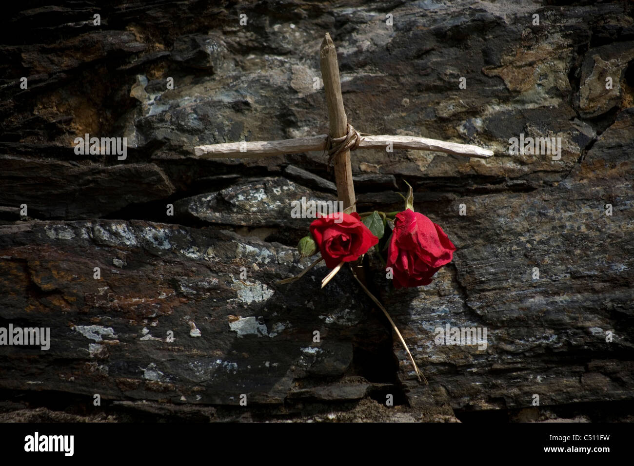 Une croix de bois et deux roses décorer un mur d'une maison à la française de Saint James Way, Casanova, Galice, Espagne Banque D'Images