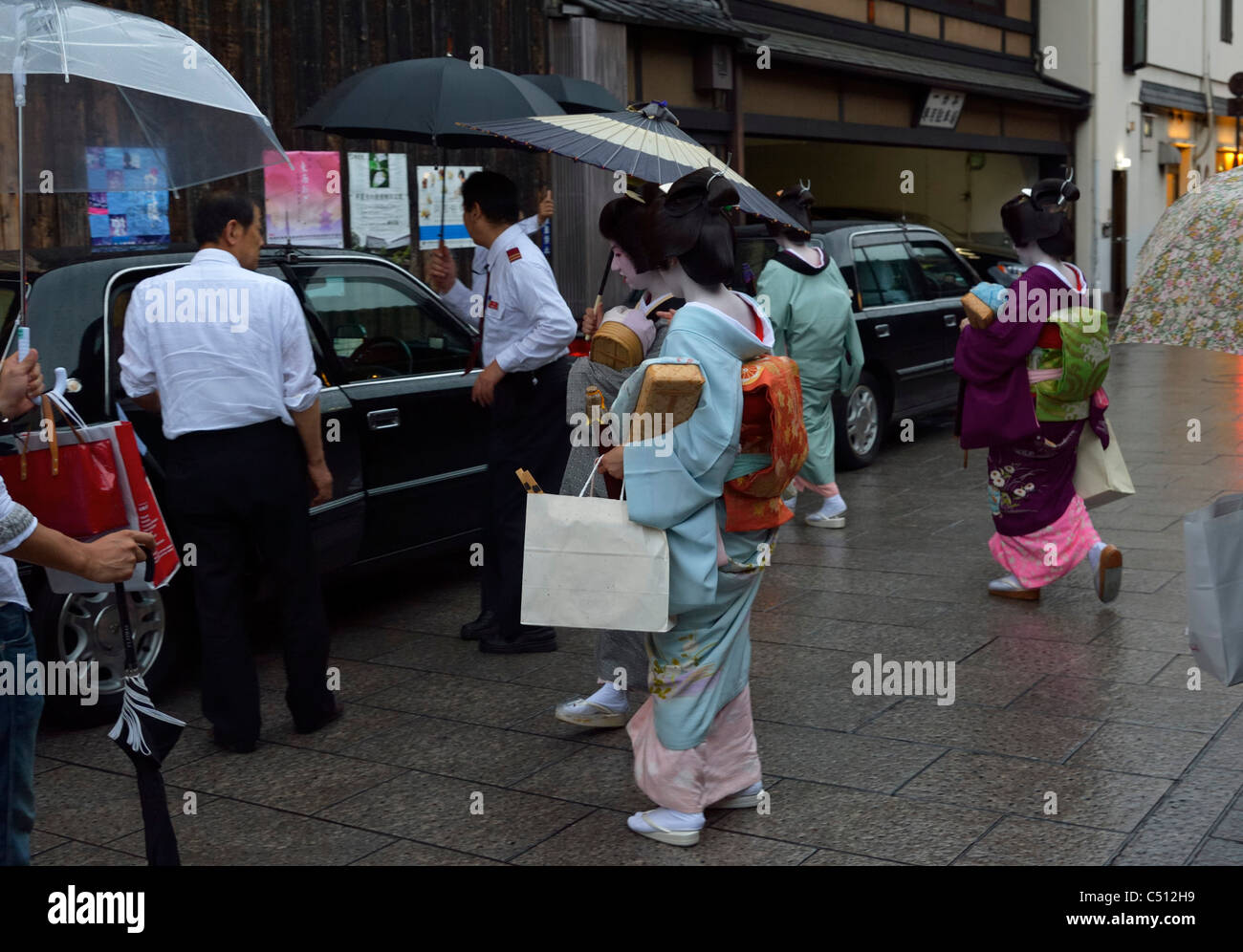 Quatre Maiko (apprenti Geisha japonaise) marcher à un taxi dans l'historique quartier de Gion, Kyoto, Japon JP Banque D'Images