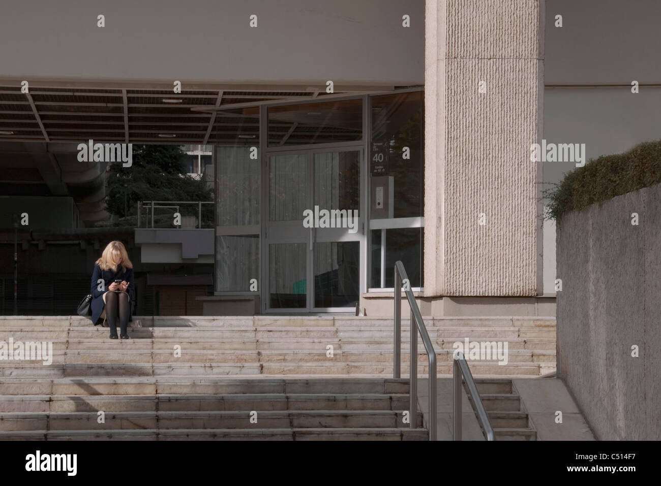 Femme assise sur les marches de la messagerie texte Banque D'Images