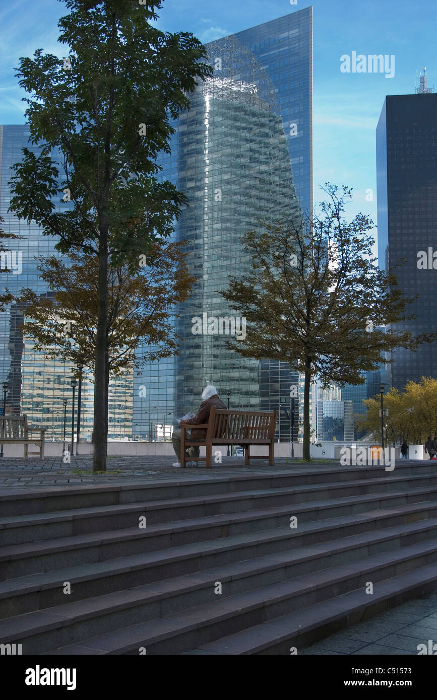 Personne assise sur un banc de lecture à office park Banque D'Images