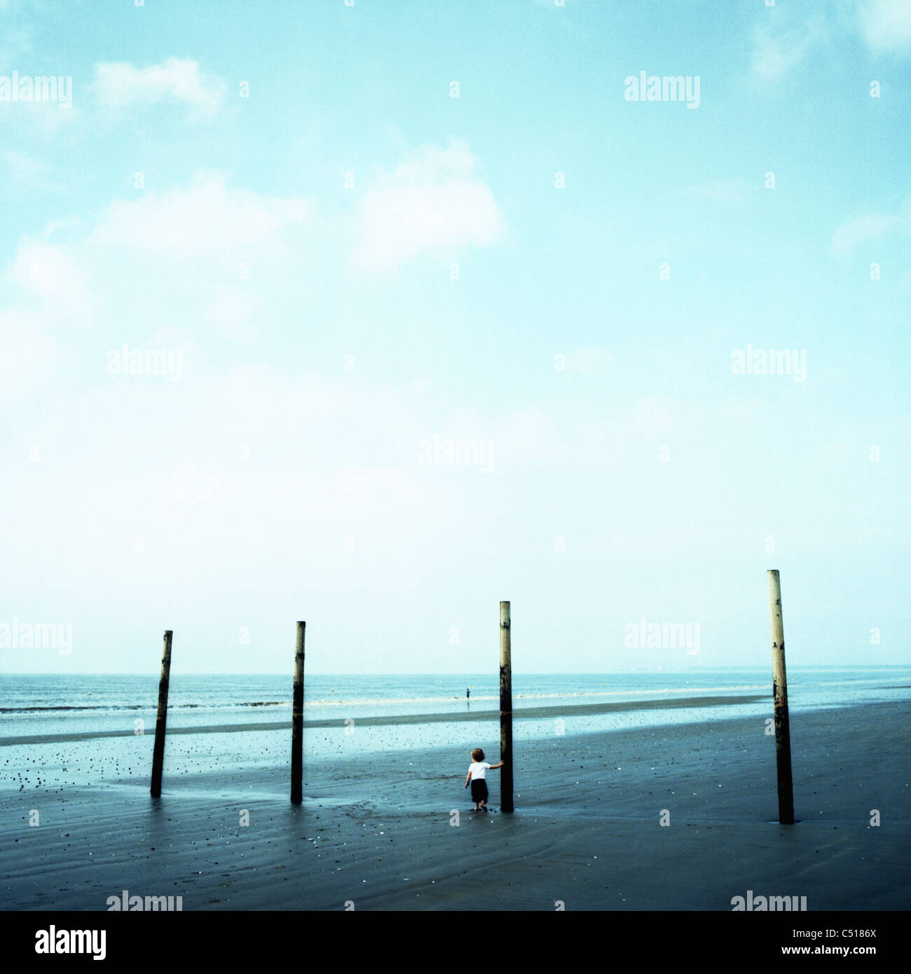 Tout-petit tout seul sur la plage à marée basse Banque D'Images