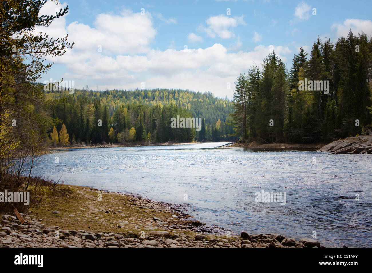 La rivière qui coule à travers le désert et ondulations frapper les rivages rocailleux de la Norvège Banque D'Images