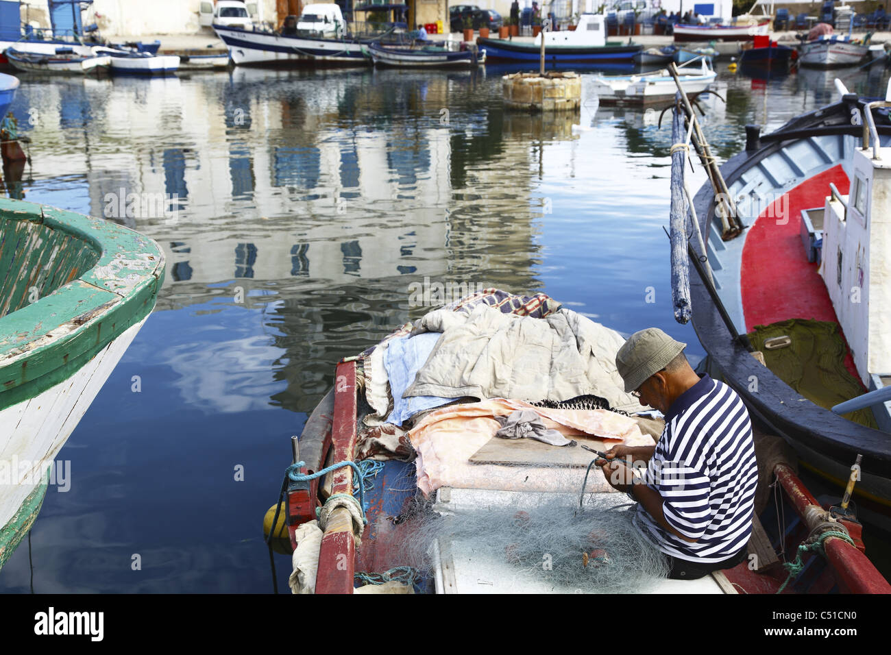 L'Afrique, Tunisie, Bizerte, Vieux Port Canal, Port, Fisherman Mending Fishing Net Banque D'Images