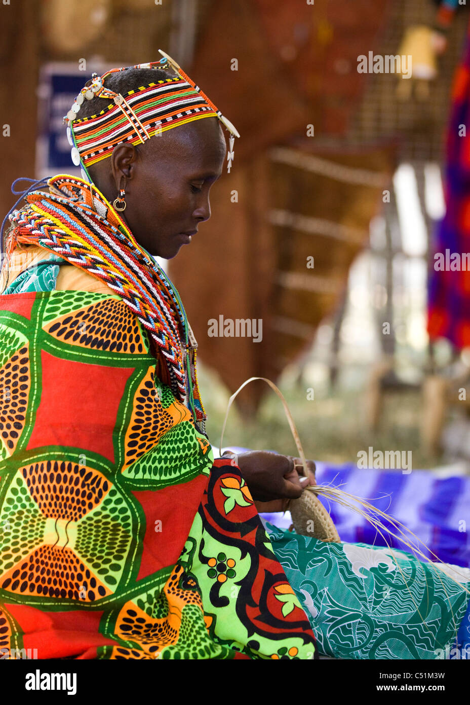 Une femme kenyane en costume traditionnel le tissage d'un panier Banque D'Images
