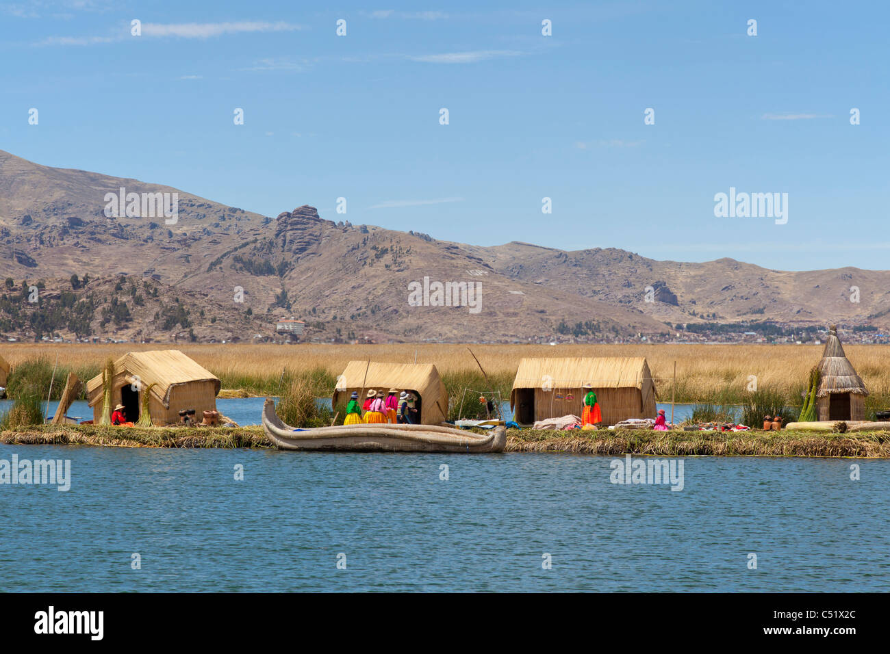 Habillés de couleurs vives sur les familles tribales des îles Uros, Lac Titicaca, Pérou Banque D'Images