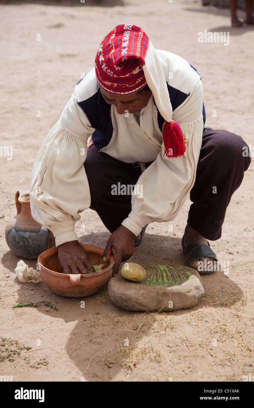 L'homme en costume traditionnel se lave à l'aide de laine d'herbes traditionnelles, Isla Taquile, Lac Titicaca, Pérou Banque D'Images