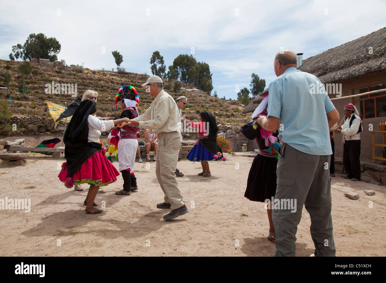 Les touristes danse avec des artistes locaux sur l'île de Taquile, Lac Titicaca, Pérou Banque D'Images