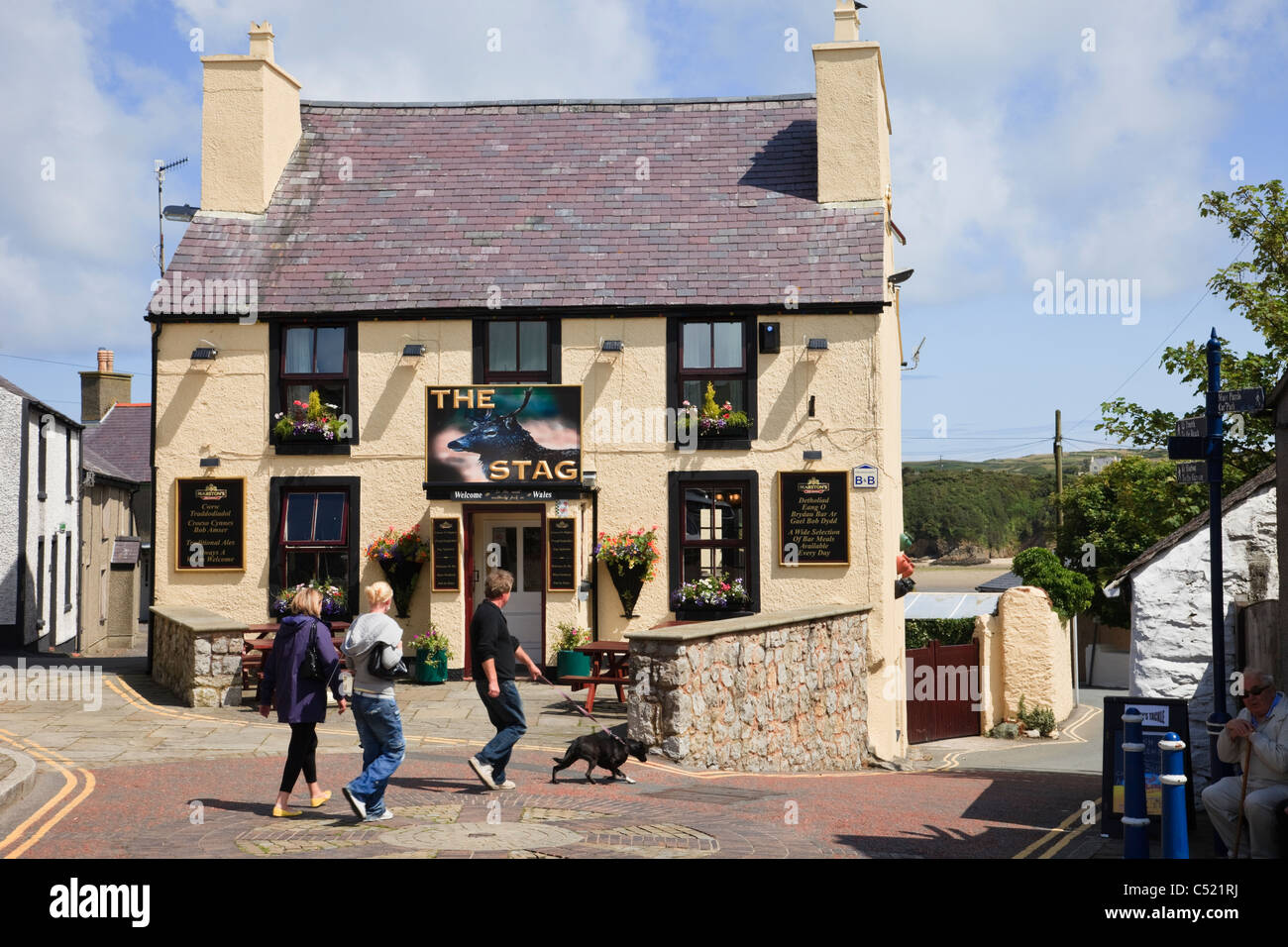 Les gens qui passent le Stag Inn pub plus au nord, au Pays de Galles. Cemaes, Isle of Anglesey, au nord du Pays de Galles, Royaume-Uni, Angleterre. Banque D'Images
