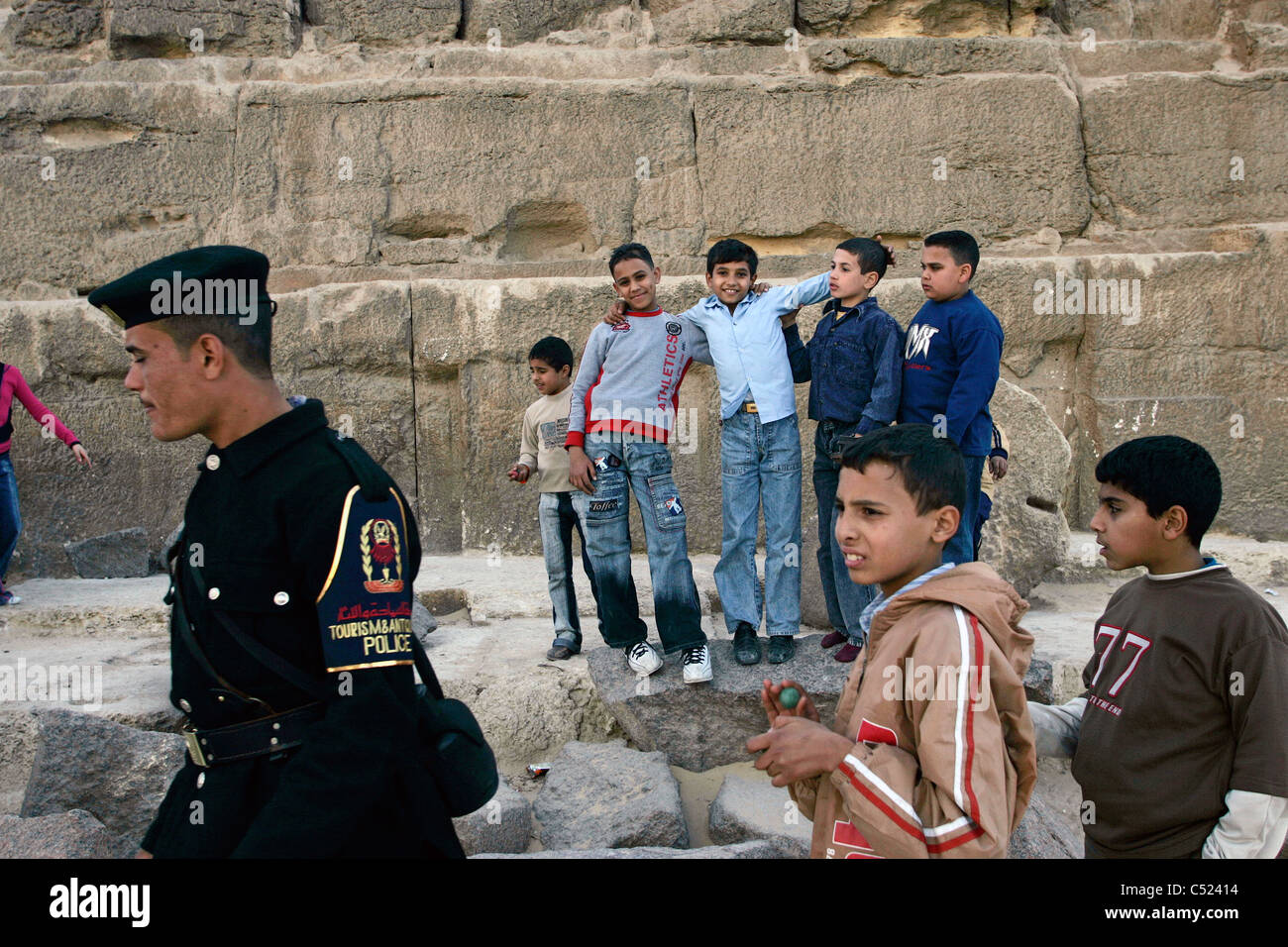 Une partie de l'école égyptienne enfants posent pour la caméra à la base de la grande pyramide de Gizeh, Le Caire, Egypte Banque D'Images