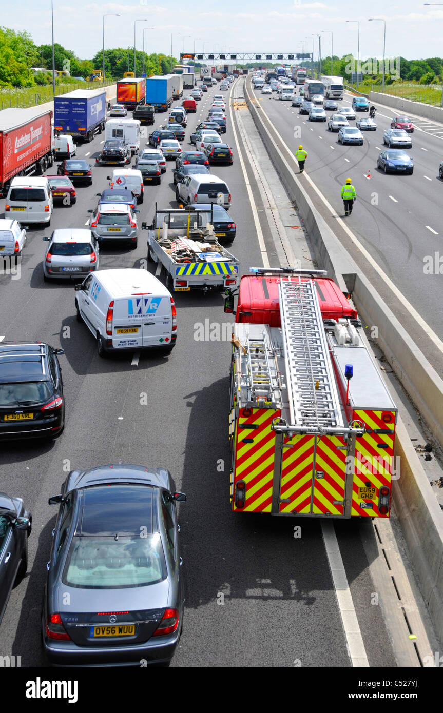 Vue du dessus vers le bas à la sur occupation autoroute M25 embouteillage services d'urgence pour assister à deux accidents sur les deux directions de pompiers arrivant UK Banque D'Images