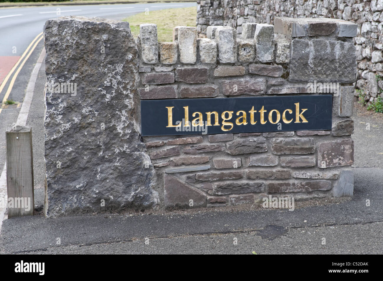 Bordure de village sign in ardoise avec surround pierre personnalités au sud du Pays de Galles Powys UK Banque D'Images