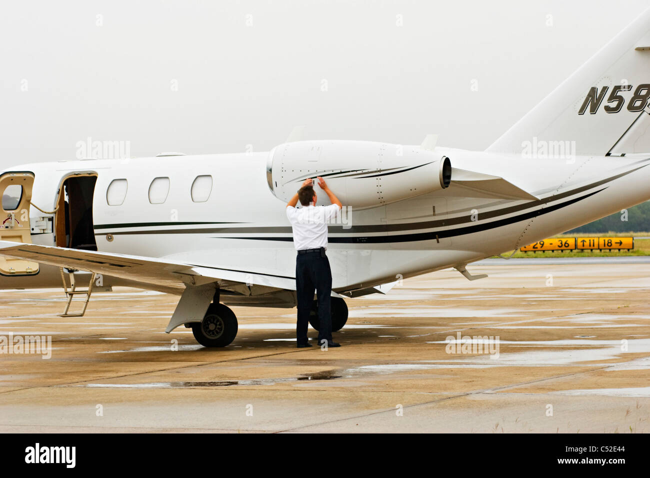 Pilote d'avion faisant inspection prévol de l'avion à réaction modeste Banque D'Images