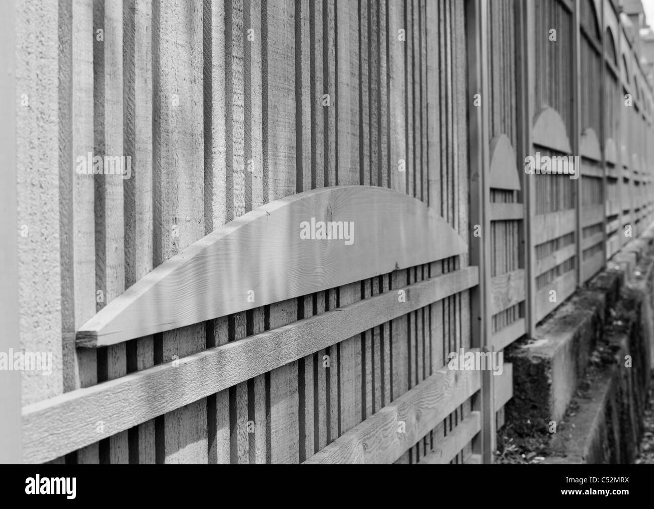 Image en noir et blanc d'une clôture en bois au design unique en perspective décroissante Banque D'Images