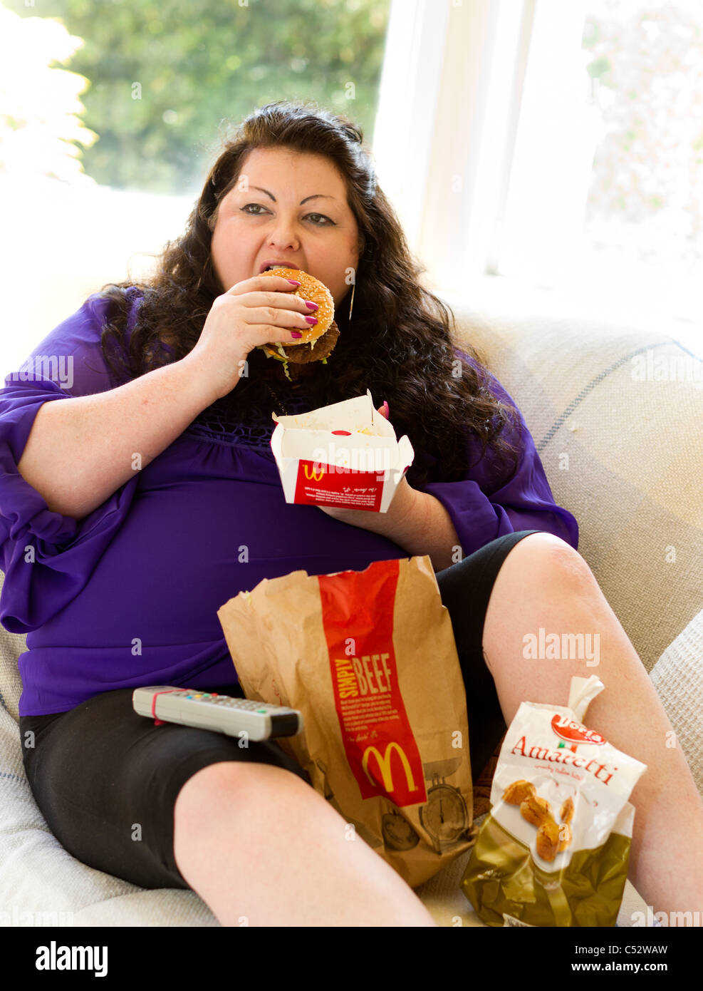 Femme mangeant des aliments gras Banque D'Images