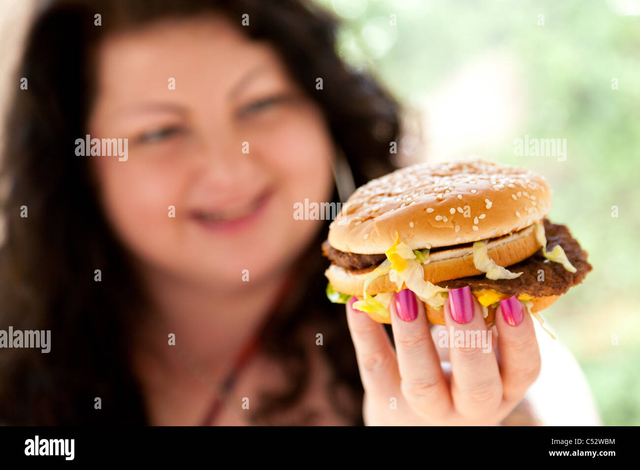 Femme mangeant des aliments gras Banque D'Images