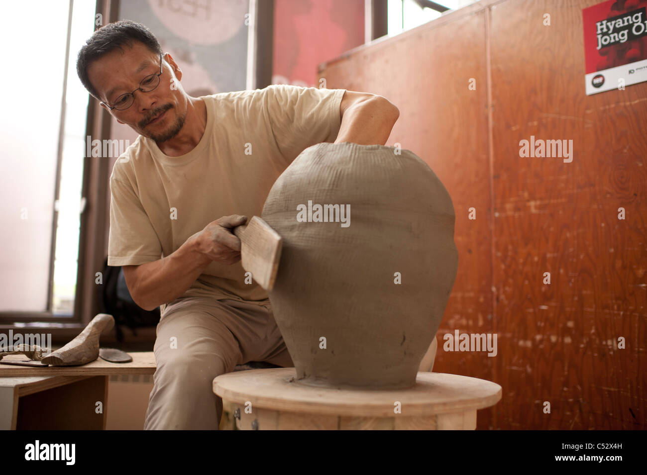 HYANG JONG OH la céramique coréenne bouilloire, mettant la touche finale à l'un de ses énormes bâtiments lors de la fête internationale de céramique Banque D'Images