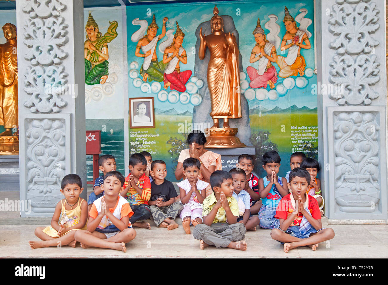 Les enfants et l'enseignant prier dans le temple de Weherahena Matara, au Sri Lanka, en Asie Banque D'Images