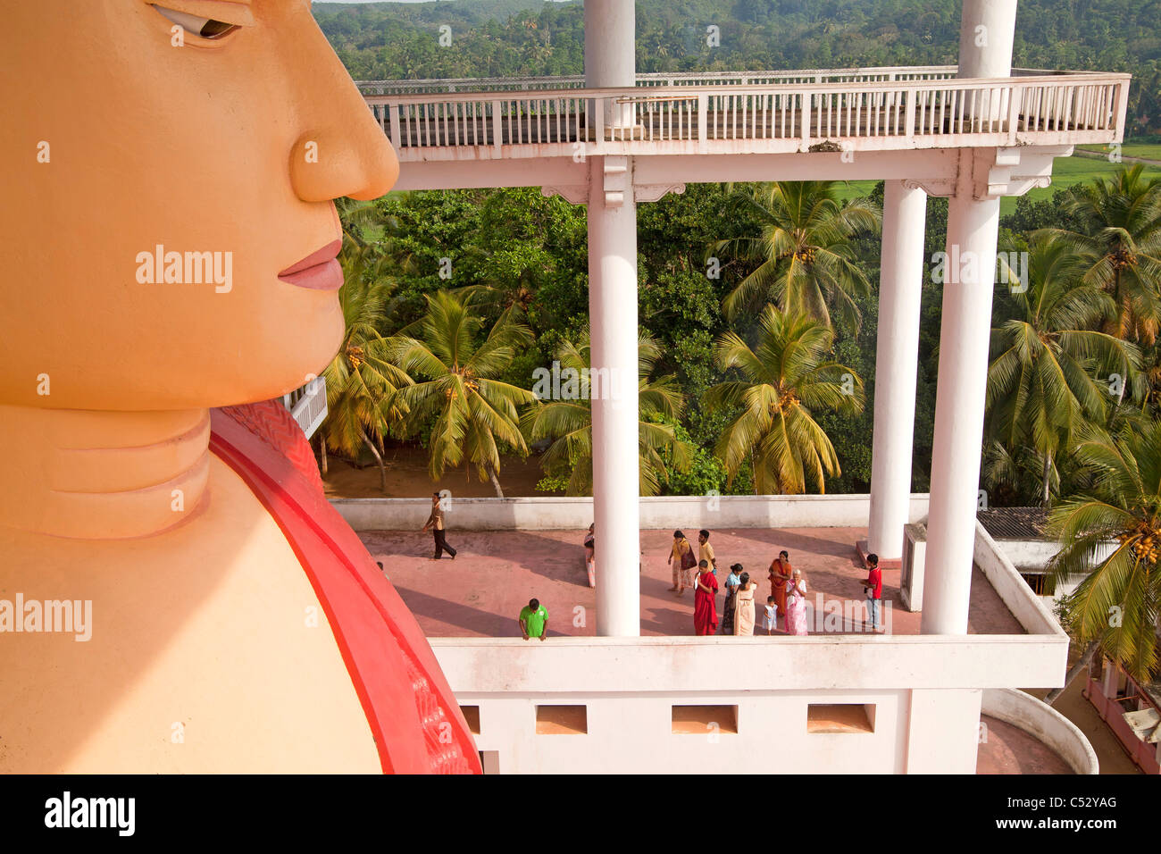 Visiteurs à la statue du Bouddha de plusieurs étages dans l'Weherahena temple de Matara, au Sri Lanka, en Asie Banque D'Images