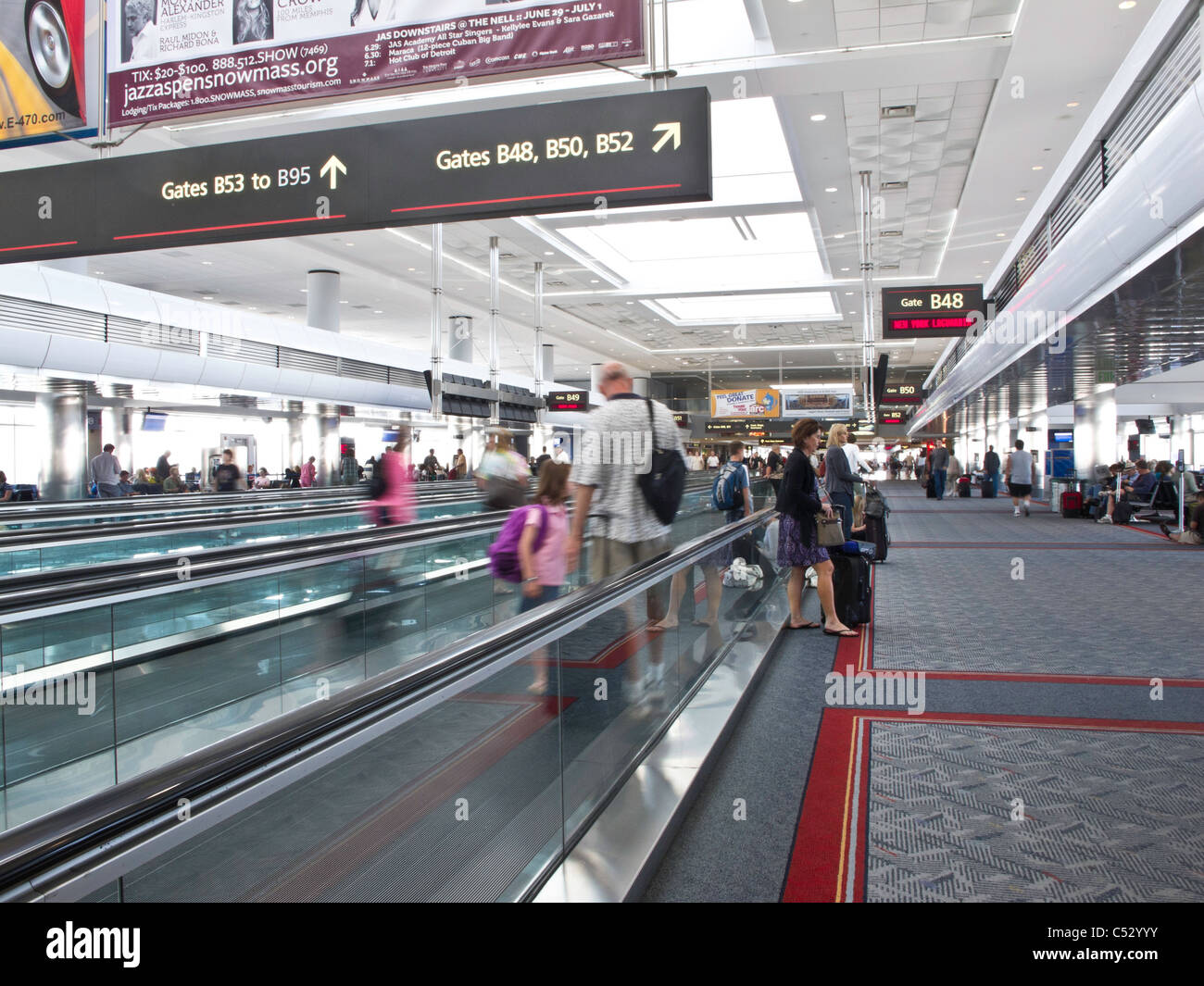 Les voyageurs de l'aéroport, trottoirs roulants et portes, United Terminal, l'Aéroport International de Denver, CO Banque D'Images