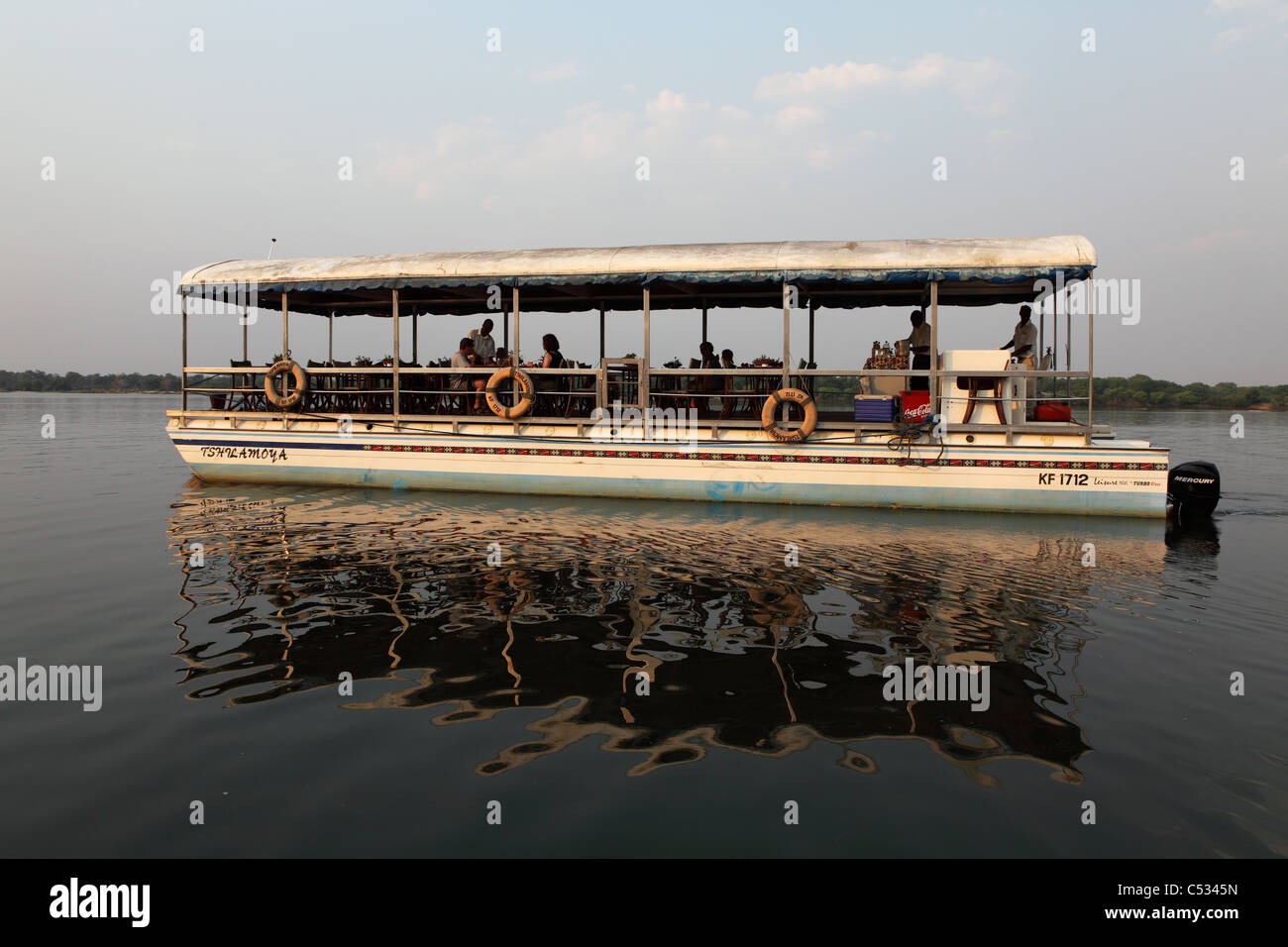 Un bateau emmène les touristes sur une soirée croisière sur le fleuve Zambèze en Afrique australe. Banque D'Images