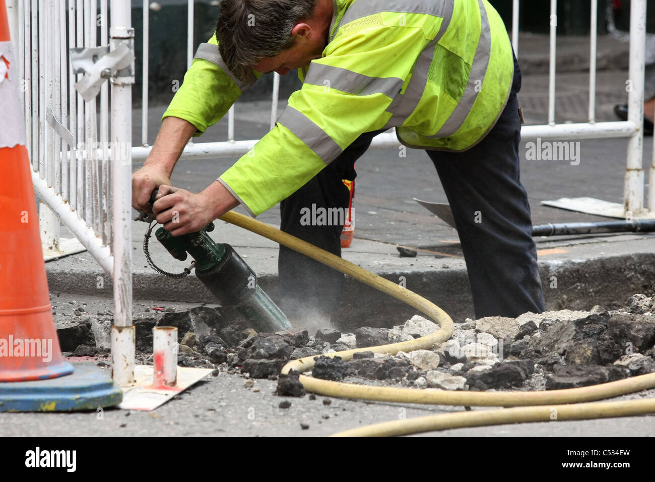 Un ouvrier à l'aide d'un marteau pneumatique des travaux routiers à Londres, Angleterre Banque D'Images