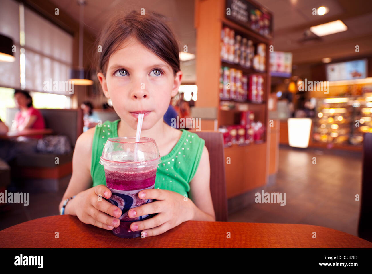 Girl drinking smoothie in coffee shop Banque D'Images