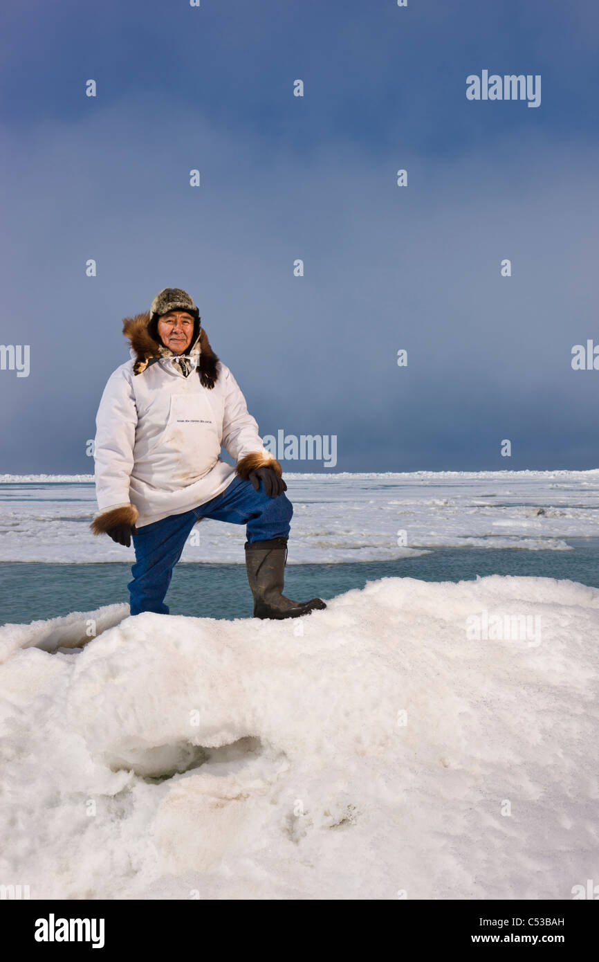 En Esquimau Inupiak mâle parc traditionnel stans sur une des crêtes de pression, la glace de mer de Tchoukotka près de Barrow, Alaska Banque D'Images
