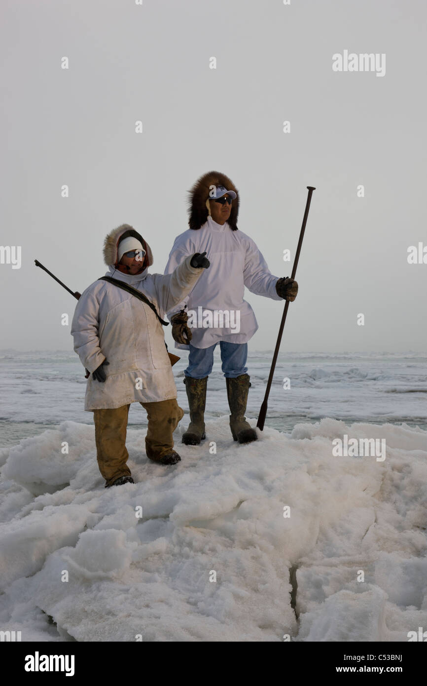 Esquimau Inupiak en chasseurs porter parkas un fusil et bâton de marche tout en admirant la mer de Tchoukotka, Barrow, Alaska Banque D'Images