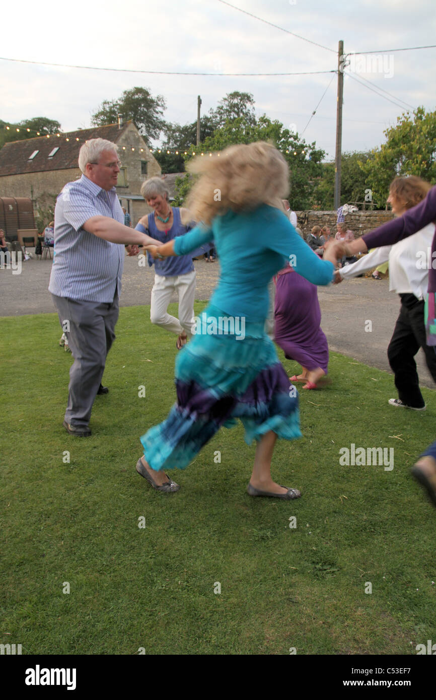 PEPLE LA DANSE À LA MUSIQUE FOLKLORIQUE TRADITIONNELLE ANGLAISE DANS UN CEILIDH AU FARM dans le Somerset, England, UK Banque D'Images