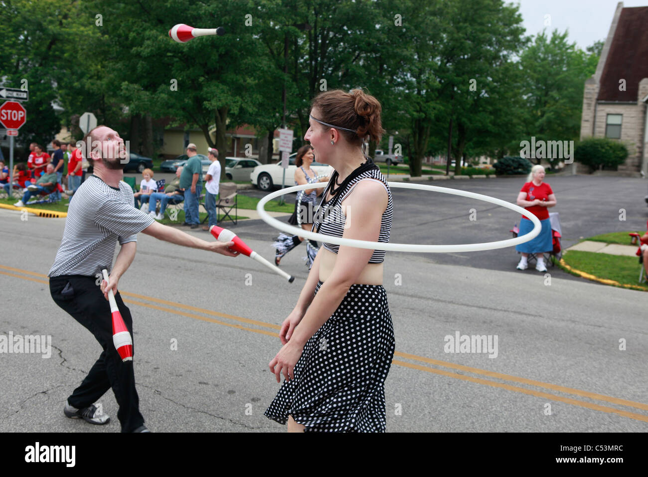 Défilé du 4 juillet --- Bloomington Hula Hoop girl frappé par les hommes au cours de jongleur 4 juillet Parade --- Bloomington Banque D'Images