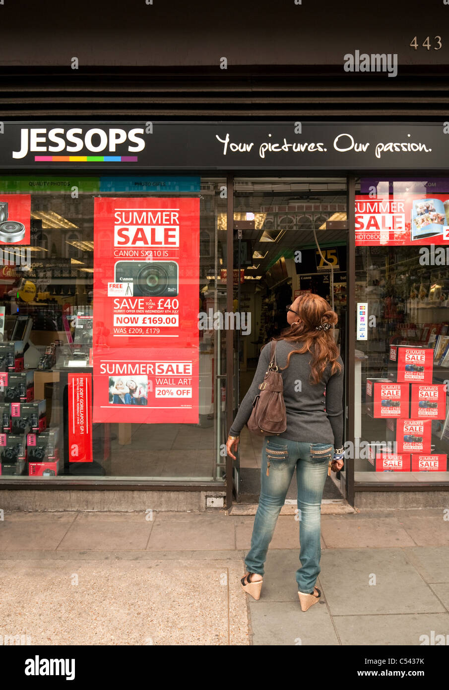 Une femme à la recherche de panneaux pour une vente au magasin, le photographique Jessops Strand, London UK Banque D'Images