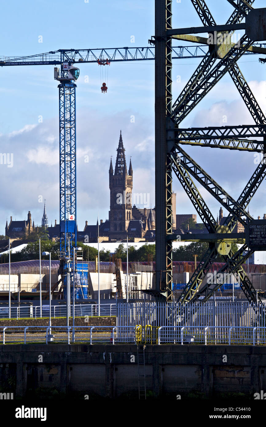 Les grues de construction à Glasgow sur le site Scottish Hydro Arena, Glasgow, Ecosse, Royaume-Uni. Tour de l'université à l'horizon. Banque D'Images