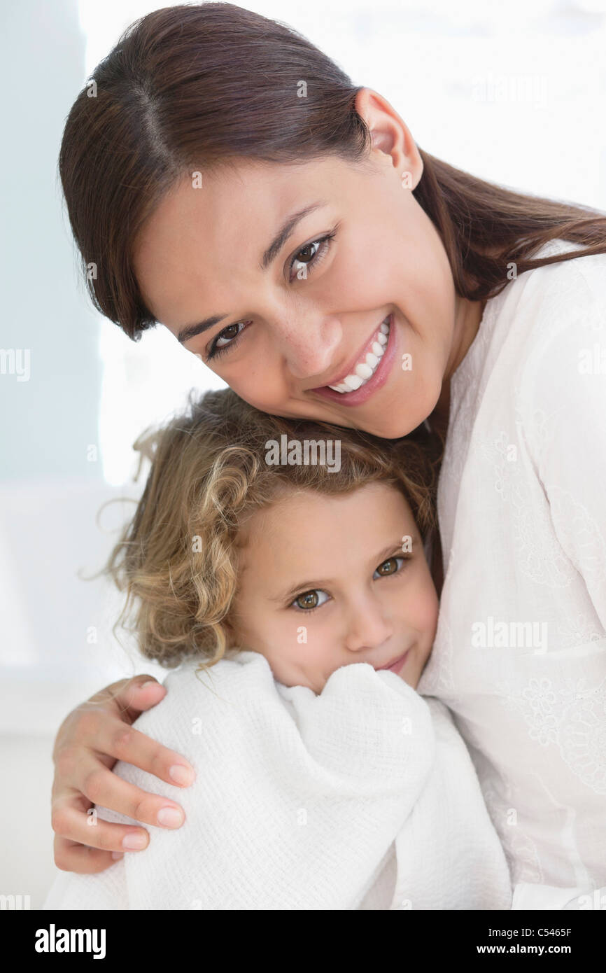 Portrait of a woman hugging her daughter enveloppé dans une serviette Banque D'Images