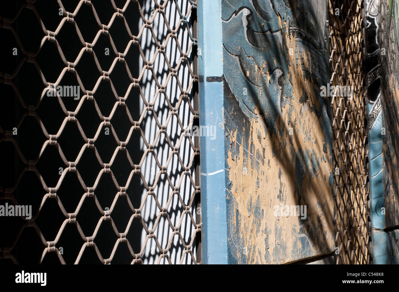 Clôture en fil de poulet, de la peinture et des ombres Banque D'Images