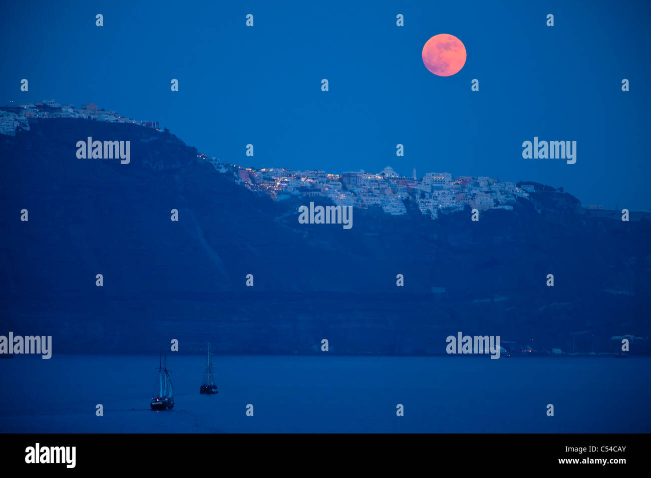 Pleine lune s'élève au-dessus de l'île de Santorin dans les Cyclades, Grèce Banque D'Images