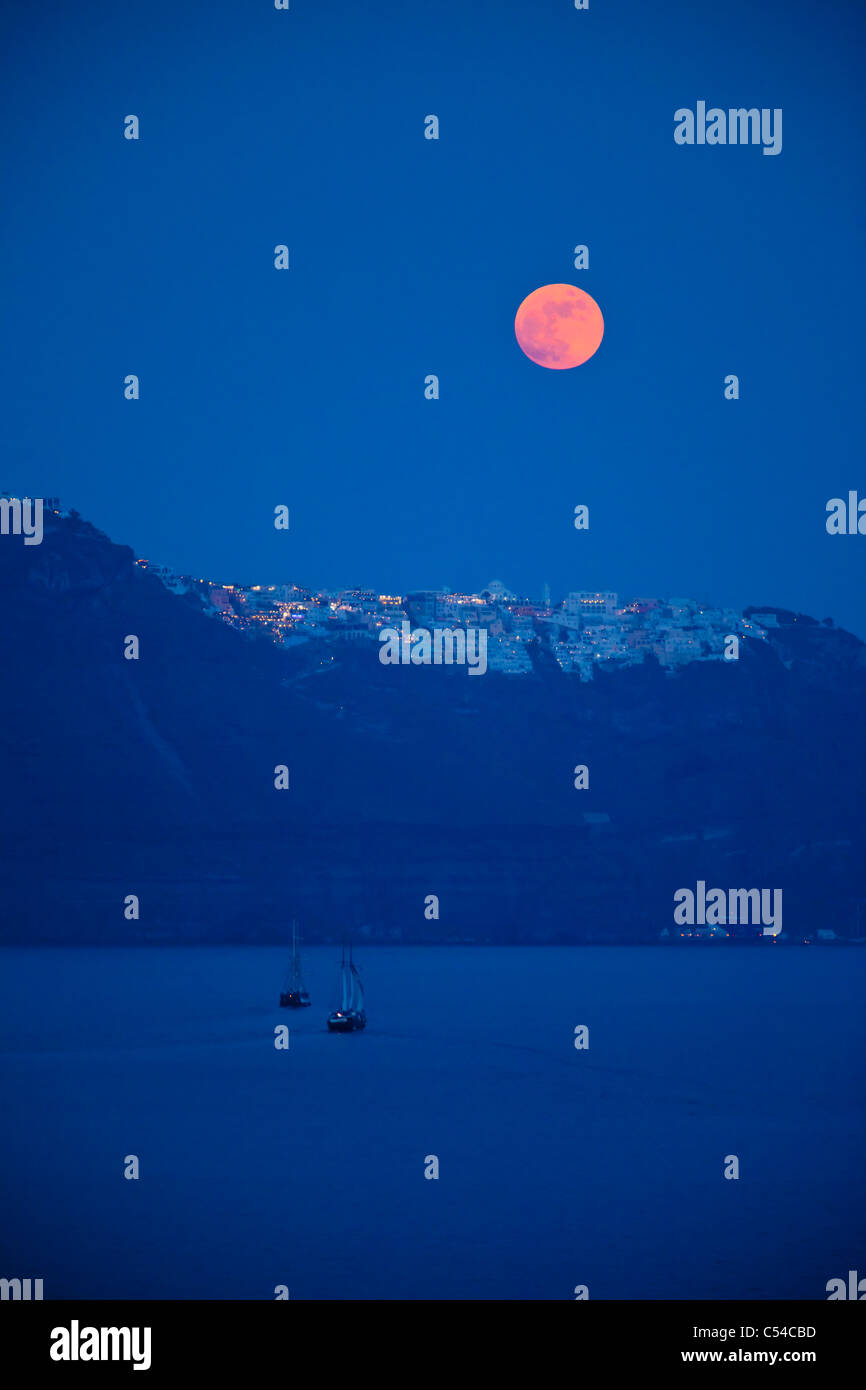 Pleine lune s'élève au-dessus de l'île de Santorin dans les Cyclades, Grèce Banque D'Images